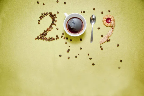 Year 2019 numbers made of coffee beans, cup od coffee, spoon and cookies. New year concept.
