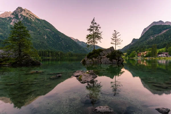 Gyönyörű jelenet fák egy szikla sziget és hegyek naplementekor nyáron, Lake Hintersee Nemzeti Park Berchtesgadener Land, Felső-Bajorország, Németország, Európa Stock Kép