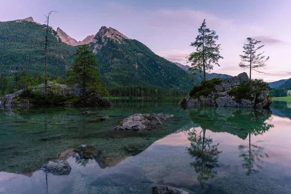 Gyönyörű jelenet fák egy szikla sziget és hegyek naplementekor nyáron, Lake Hintersee Nemzeti Park Berchtesgadener Land, Felső-Bajorország, Németország, Európa Jogdíjmentes Stock Fotók