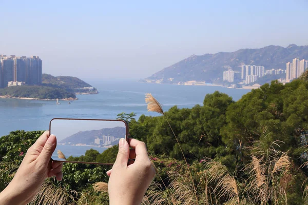 観光で香港の携帯電話を使用して海岸の風景の写真を撮る — ストック写真