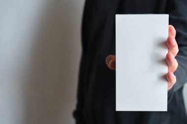 Elinde küçük bir karton kutu tutan adam. Boş ambalaj, boş alan. Yeni paketli bir erkek. Posta servisi, teslimat. Beyaz kağıt. Hediye kutusu, hediye. Kutuyu kapat. İnsanlarla iletişim. Kutu kutusu