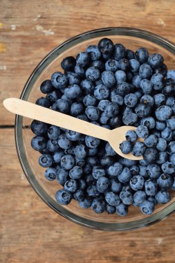 Kasedeki bir kaşıkta yaban mersini. Doğal organik meyveler. Taze, güzel yaban mersini yakından. Lezzetli yaz yabanmersini. Tatlı olarak böğürtlen. Sağlıklı yaşam tarzı, vejetaryen tatlı atıştırmalığı.