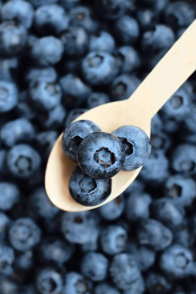 Blueberries on a spoon in a bowl. Natural organic berries. Fresh beautiful blueberry close up. Delicious summer wild berry. Berries for dessert. Healthy lifestyle, vegetarian sweet snack