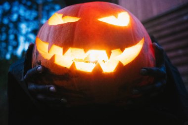 Elinde siyah bir adam Helluin kabak karanlık bir ormanda tutar.