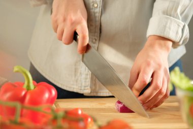Kız kırmızı soğan sebze salatası için keser. Yemek salata