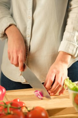 Kız kırmızı soğan sebze salatası için keser. Yemek salata