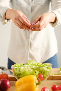 Kız bir sebze salatası hazırlar. Dikey fotoğraf