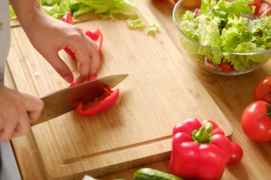 Kız tatlı biber sebze salatası keser. Sala pişirme