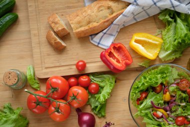 Çeşitli taze sebze ve çiftlik ekmek ahşap bir masa üzerinde. Sonbaharda hasat ve sağlıklı doğal gıda kavramı.