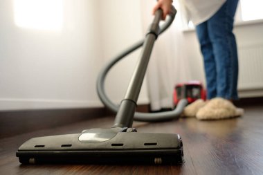 Kız beyaz bir gömlek ve bir vakum cleane ile temizlik yapıyor kot