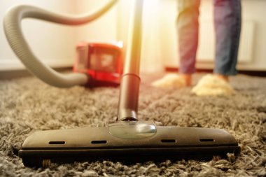 Kız beyaz bir gömlek ve bir vakum cleane ile temizlik yapıyor kot