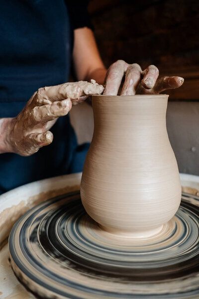 Создание вазы и моделирование глины в профессиональной мастерской керамики
