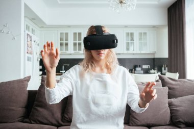 Genç Sarışın evde modern bir tasarım ile sanal gerçeklik gözlüklerini koyar