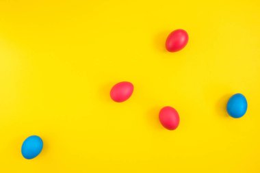 Kırmızı ve sarı zemin üzerine mavi boyalı yumurta yaratıcı düzeni