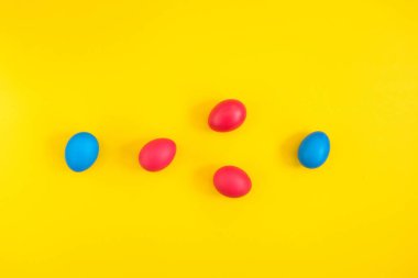 Kırmızı ve sarı zemin üzerine mavi boyalı yumurta yaratıcı düzeni