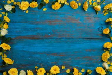 Çiçek kompozisyon. Mavi bir ahşap zemin üzerine sarı çiçek çerçeve yaptı. Paskalya, bahar, yaz konsepti. Düz yatıyordu, top vie