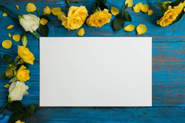 Çiçek kompozisyon. Mavi bir ahşap zemin üzerine sarı çiçek çerçeve yaptı. Paskalya, bahar, yaz konsepti. Düz yatıyordu, top vie