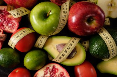 Sağlıklı gıda. Sebze ve meyve. Ölçüm bandı. Siyah bir arka plan üzerinde. Üstten görünüm.
