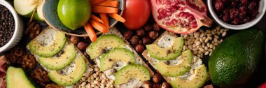 Crispbread peynir ve avokado, domates, fındık, meyve, salata, karanlık kurulu arka plan üstten görünüm üzerinde baharatlar. Gıda ve sağlık