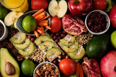 Crispbread peynir ve avokado, domates, fındık, meyve, salata, karanlık kurulu arka plan üstten görünüm üzerinde baharatlar. Gıda ve sağlık