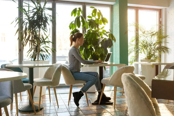 Het Meisje Werkt Computer Een Café Met Verse Bloemen — Stockfoto