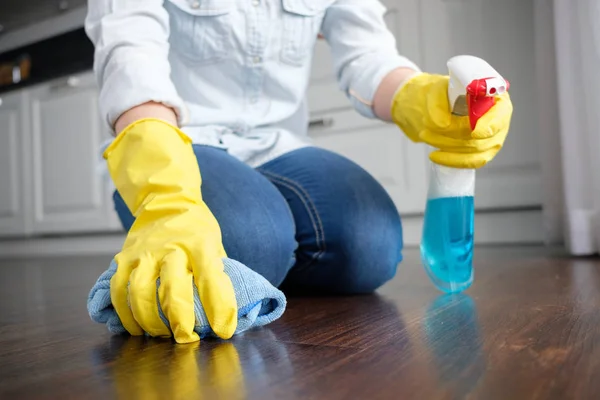 The girl washes the floor at home