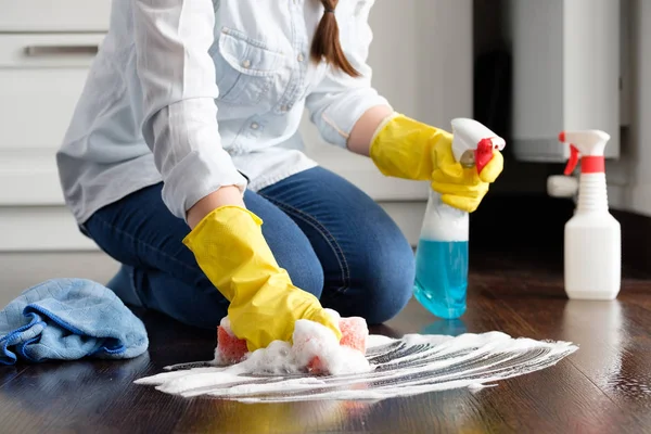 The girl washes the floor at home