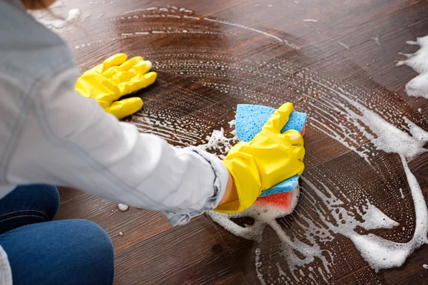 The girl washes the floor at home