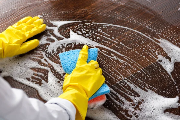 The girl washes the floor at home