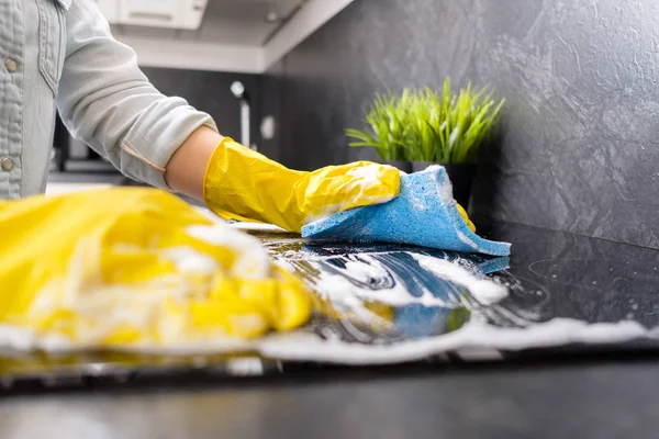 女孩用黄色手套用蓝色海绵洗炉子 — 图库照片