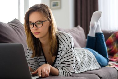 Kız bir bilgisayarın önünde evde zaman geçiriyor