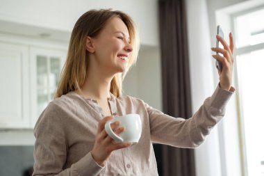 Mutfakta telefonla konuşan bir kız.