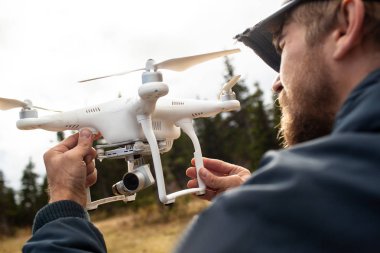Erkek turist yeni yerler keşfetmek. Yakıt ile niteliğine yakışıklı sakallı adam. Drone kullanarak fotoğraf arşivi ve doğa vuruyor