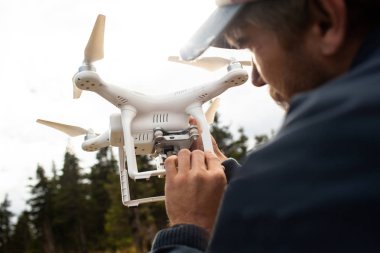Erkek turist yeni yerler keşfetmek. Yakıt ile niteliğine yakışıklı sakallı adam. Drone kullanarak fotoğraf arşivi ve doğa vuruyor