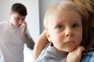 Bir çocuk annemi arka planda babaya sarılıyor. Aile konsepti