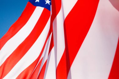 Mavi gökyüzüne karşı rüzgarda uçan Amerikan bayrağı