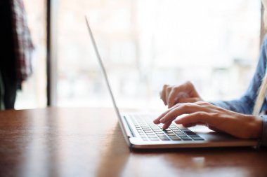 Kafede çalışan genç bir kadın, dizüstü bilgisayarda klavye. Üniversitedeki derslerden sonra netbook için çalışan sarışın bir öğrenci..