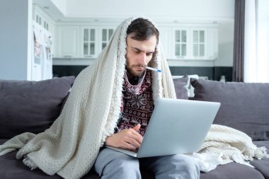 Bir laptop ile hasta adam evde çalışıyor