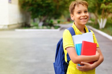    Sırt çantası ve dizüstü bilgisayarları olan çocuk