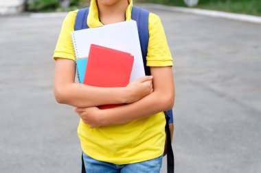 Bir çocuğun elinde ki kitaplar ve defterler