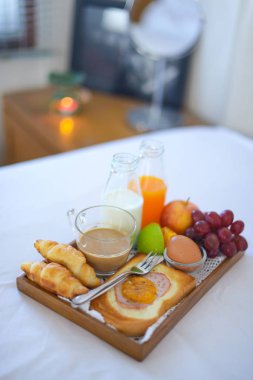 Kahve, kruvasan pencere ışık ile yatakta kahvaltı