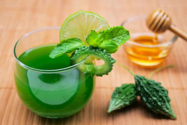 Çiğ ve dilimlenmiş acı kabalık ile acı kabalık suyu. Sağlıklı Bitkisel İçecek