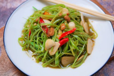 İstiridye sosu, acı biber ve sarımsak ile sotelenmiş sabah zaferi.