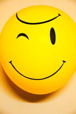 Balonlar duvarda, emoji yüzleri balonlarda.