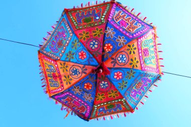 Gökyüzünde asılı bir şemsiye, renkli bir şemsiye