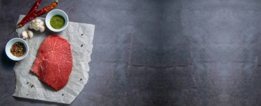 Çiğ et, arka planda biftek, açık alanlı üst manzara..