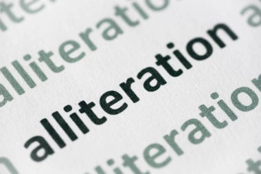 beyaz kağıt makro üzerinde basılı kelime aliterasyon