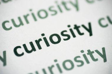 beyaz kağıt makro üzerinde basılı kelime merak