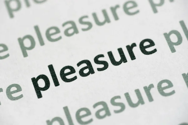 word pleasure printed on white paper macro