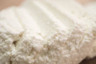 Ahşap kesme tahtası macron üzerinde beyaz peynir dilimlenmiş